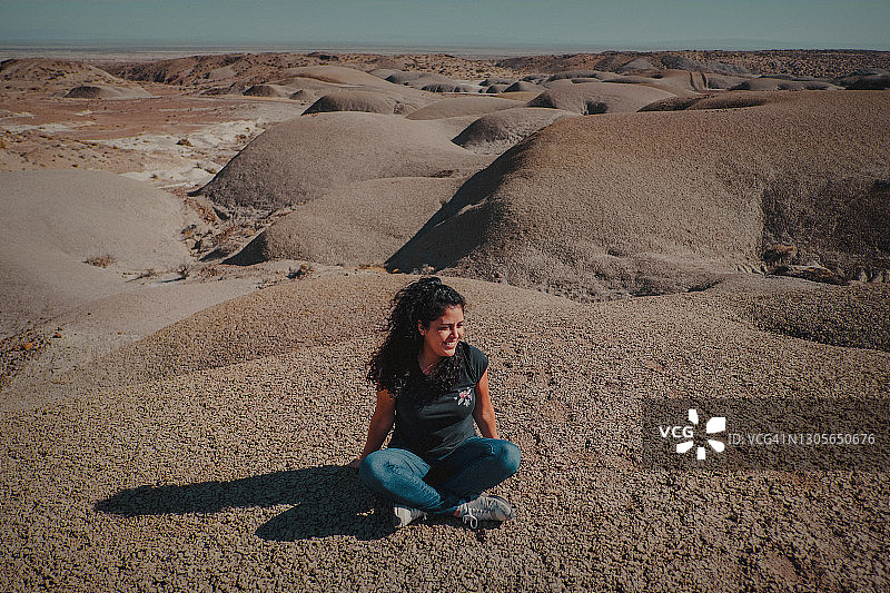 背对着巨大沙丘的女人图片素材
