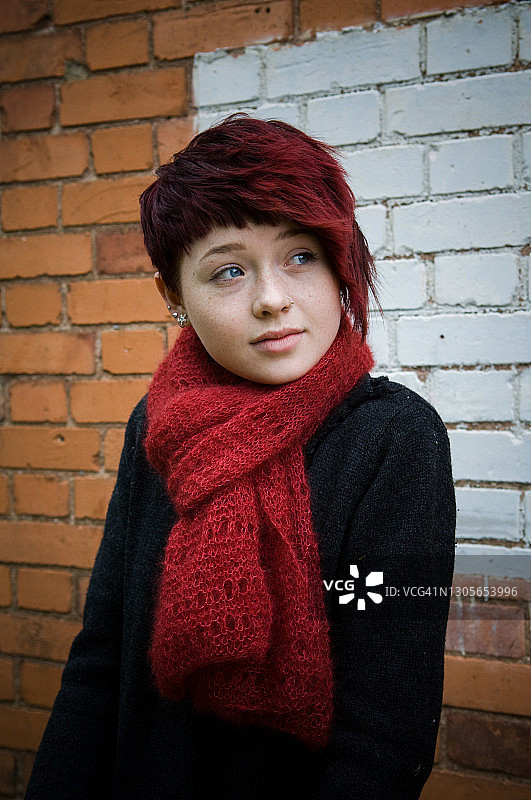在砖墙前微笑的少女图片素材