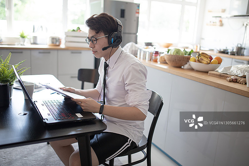 中国年轻男子在餐厅使用笔记本电脑工作图片素材