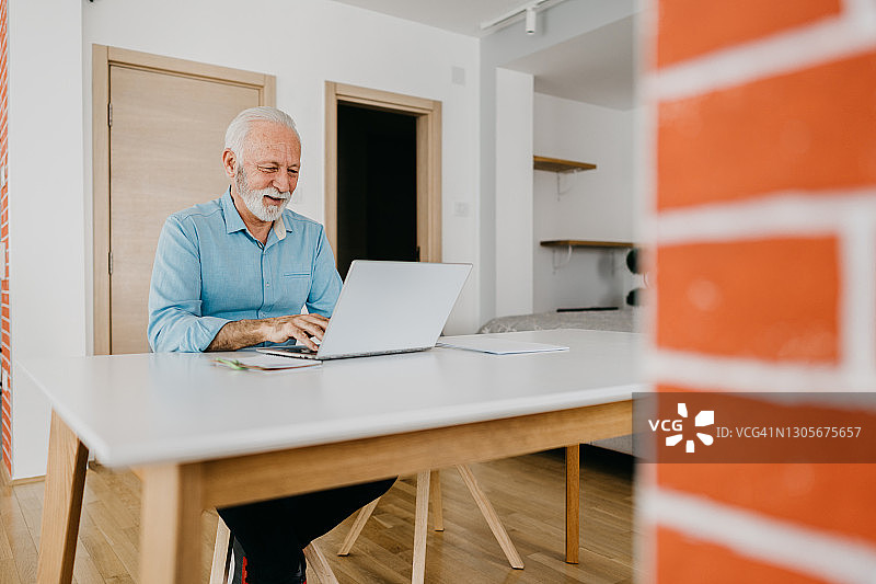 年长的男人使用信用卡在线购物图片素材