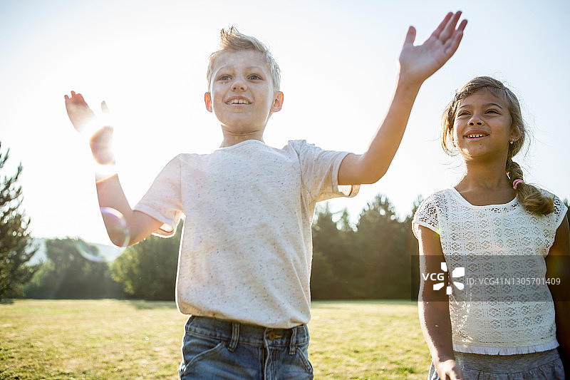 孩子们在草地上吹泡泡图片素材