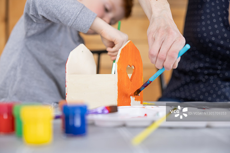母子在家一起粉刷鸟舍图片素材