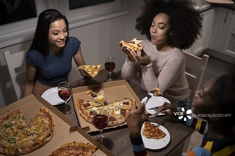 三个年轻漂亮的不同种族女人在家中聚会图片素材