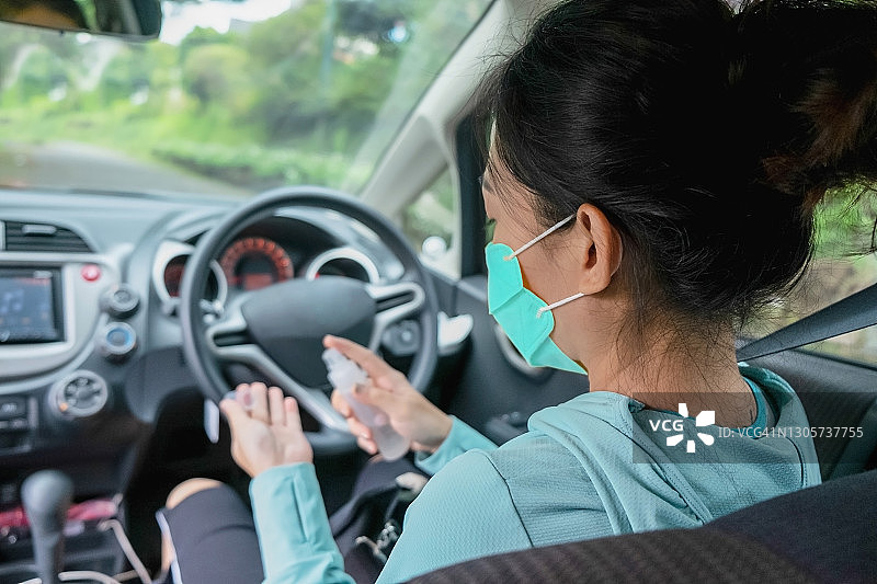在车内喷洒免洗洗手液的亚洲女司机图片素材
