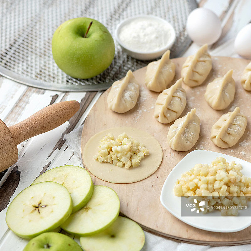 生面团圆圈上的绿色苹果馅料，纯素食品烹饪过程图片素材