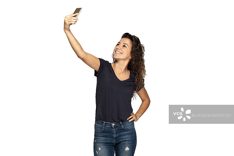 年轻女孩用智能手机自拍图片素材