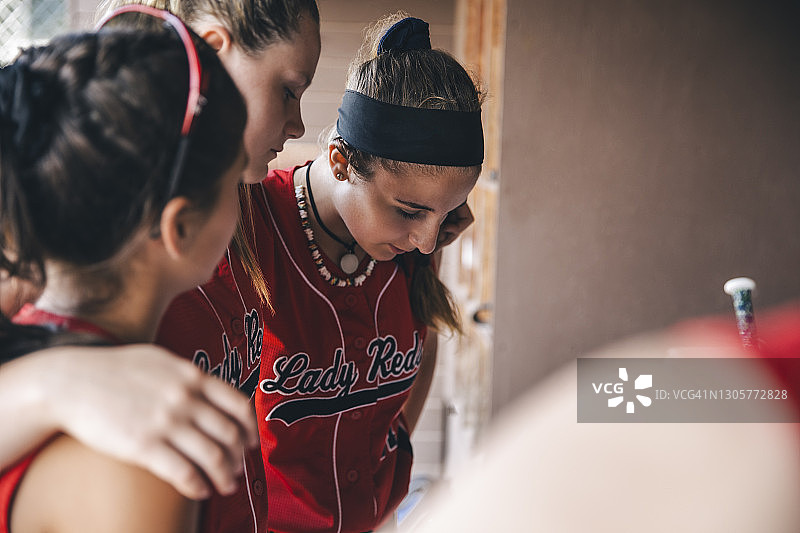 垒球比赛前，女孩们在休息区抱成一团图片素材