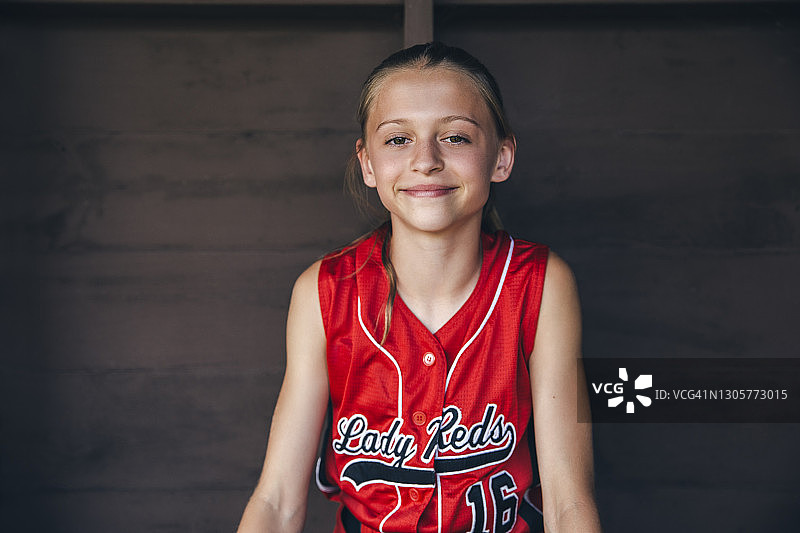 坐在休息区里的青少年垒球运动员肖像图片素材