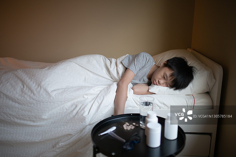 生病的中国青少年躺在床上休息图片素材