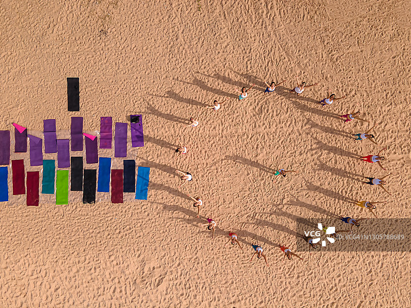 团队合作理念：亚洲女性在海滩上练习瑜伽图片素材