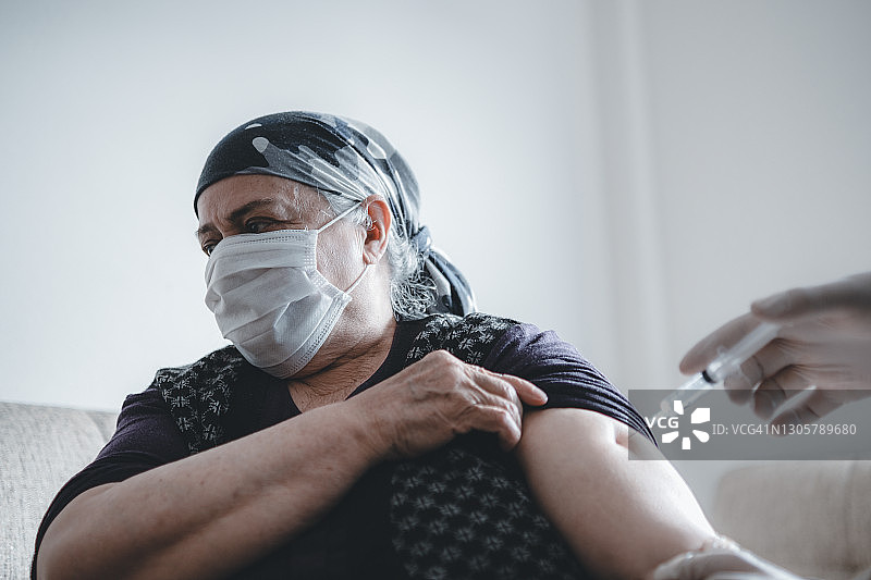 医生为老年妇女接种新冠疫苗图片素材