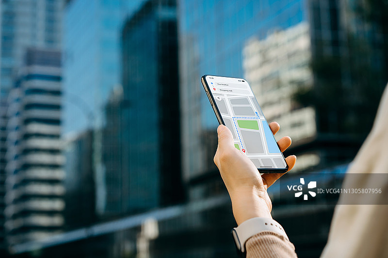 年轻女子在智能手机上使用地图App导航和搜索城市位置特写图片素材