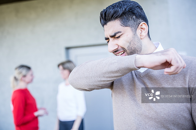 男人对着胳膊肘打喷嚏图片素材