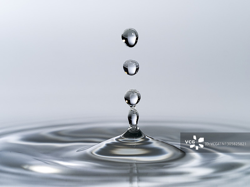 水滴群撞击白色背景液体表面图片素材