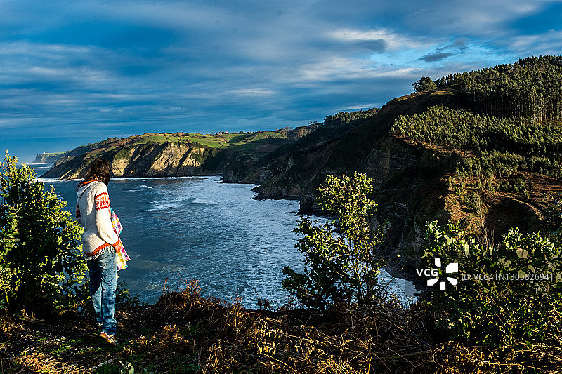 女人在西班牙北部悬崖边上的田园诗中探出身子图片素材