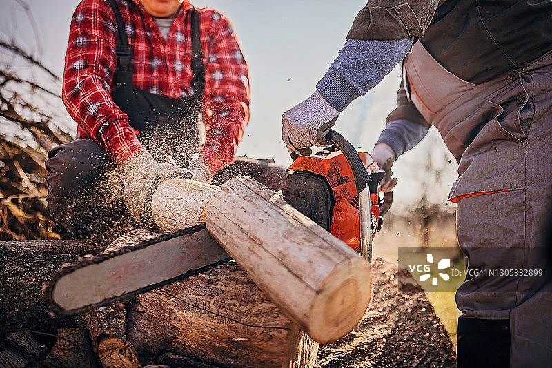 用油锯切割木头的男人图片素材