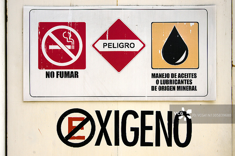 氧气储存室门上的西班牙语危险和安全标志图片素材