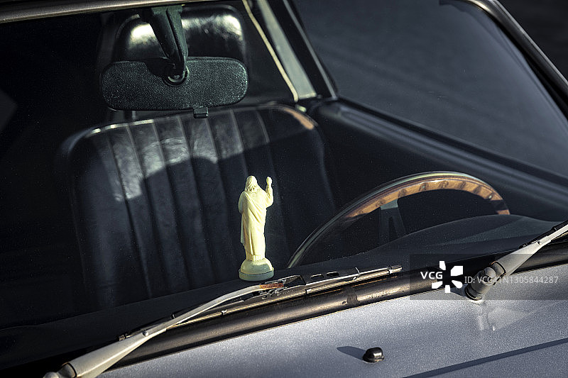 老式汽车仪表盘上的耶稣雕像图片素材