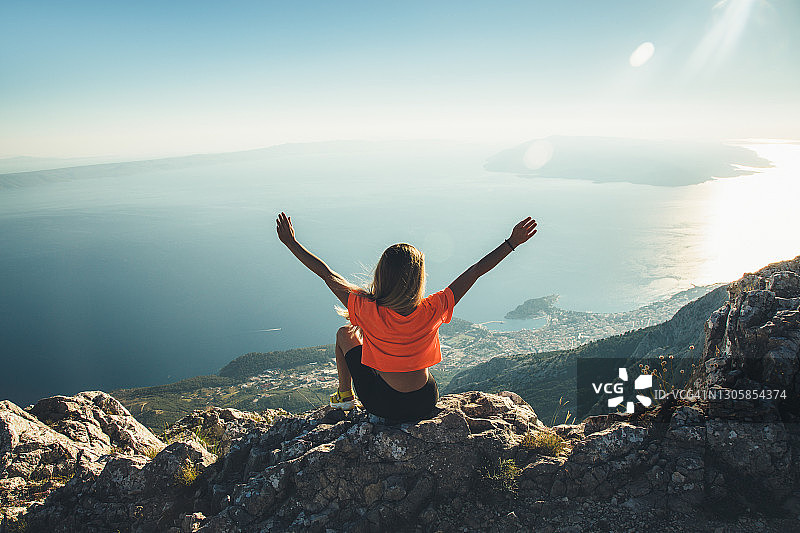坐在悬崖上的年轻女人图片素材