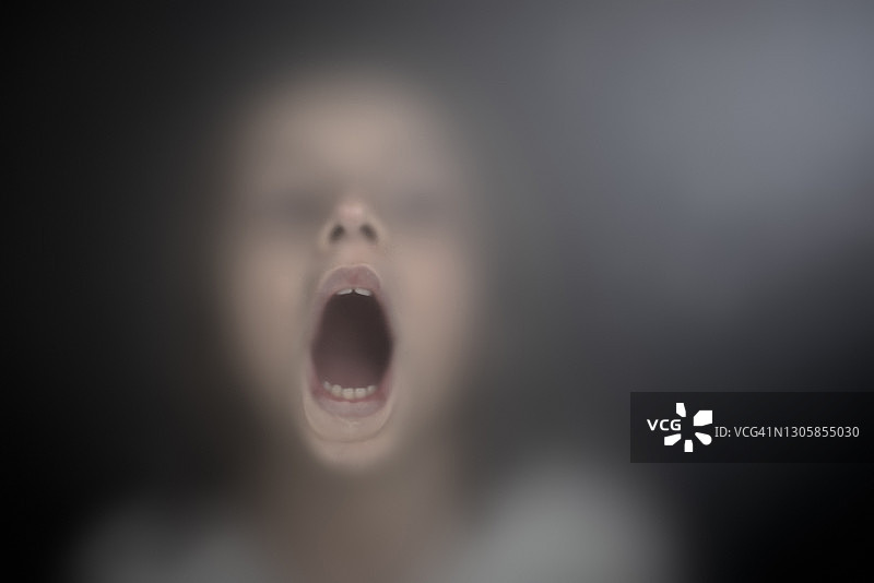 透过磨砂玻璃看到的受惊儿童图片素材