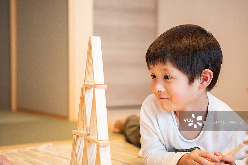 男孩惊讶地看着平衡的积木图片素材