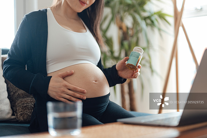 孕妇在家中使用笔记本电脑与医生进行视频通话图片素材