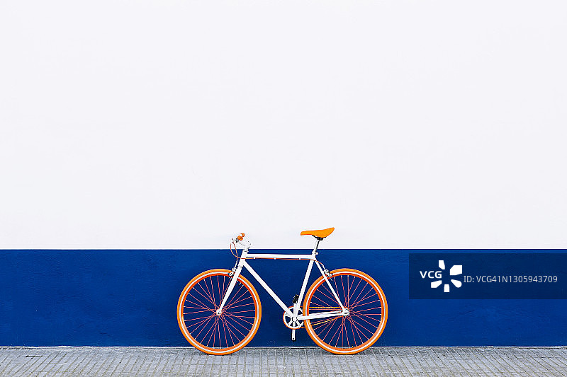 靠墙停放的橙色自行车图片素材