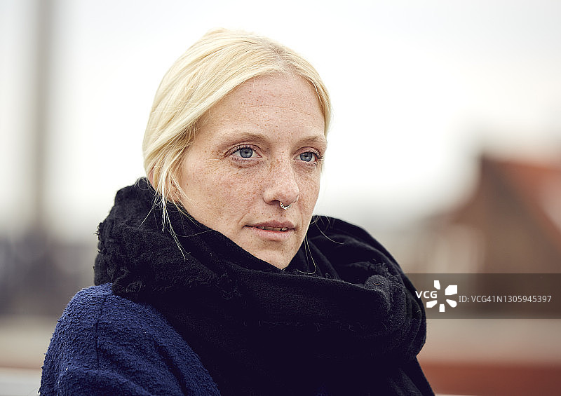 在停车场戴围巾的沉思年轻女人图片素材