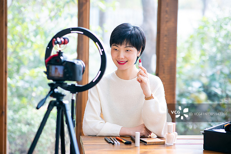 录制化妆教程视频的亚洲女性博主图片素材