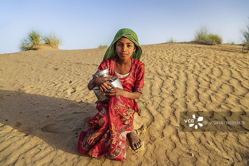 印度少女在印度沙漠村庄从井里打水图片素材
