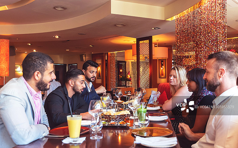 不同族裔的朋友们在迪拜的印度餐厅享用周末早午餐图片素材
