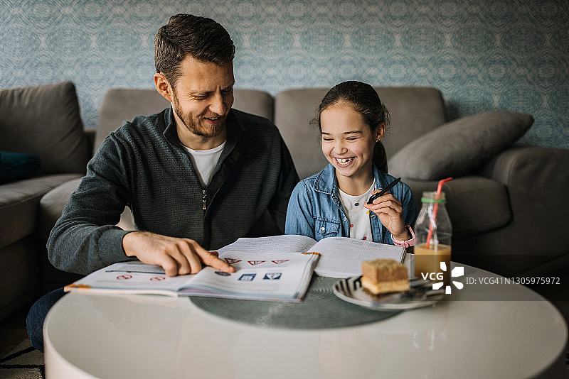 慈爱父亲在家辅导女儿写作业图片素材