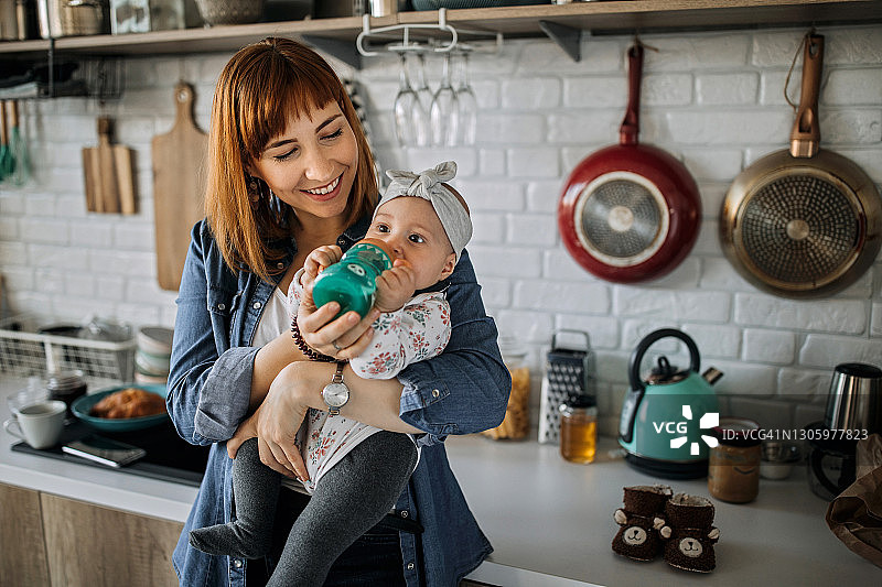 母亲给女婴喂水图片素材