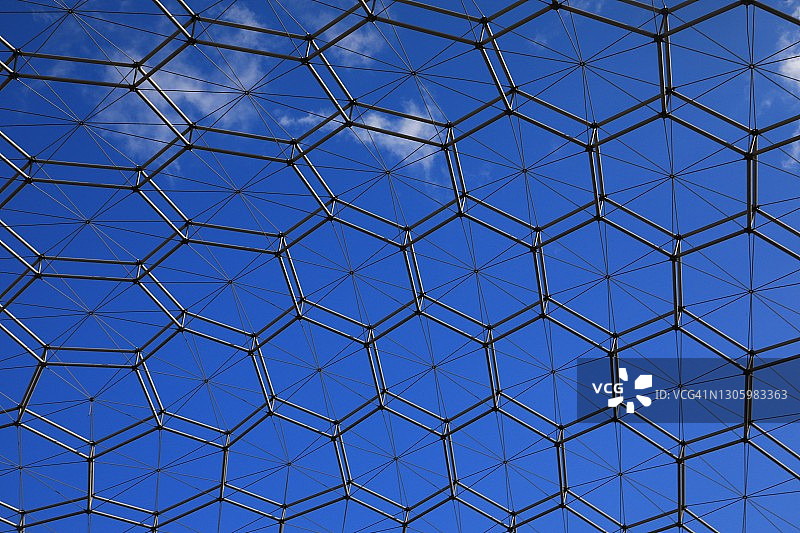 蓝色天空下的网格状球顶结构图片素材