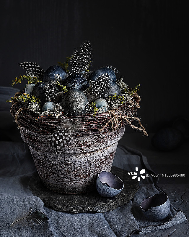 花盆中的复活节装饰，配有树枝花环、彩蛋和羽毛图片素材