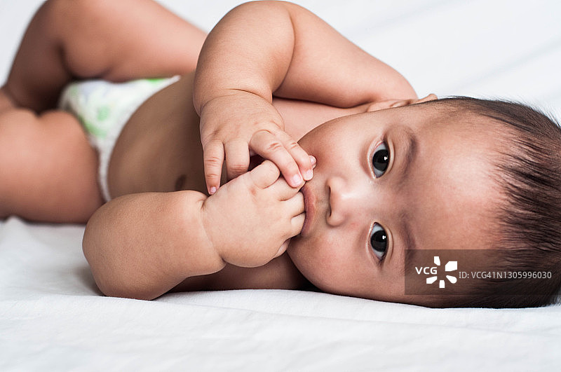 躺在床上的东南亚男婴肖像图片素材