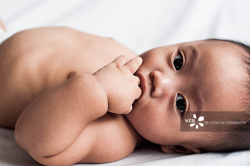 躺在床上的东南亚男婴肖像图片素材