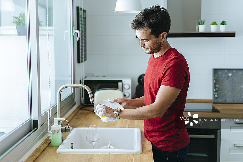 男人在家里厨房洗碗图片素材