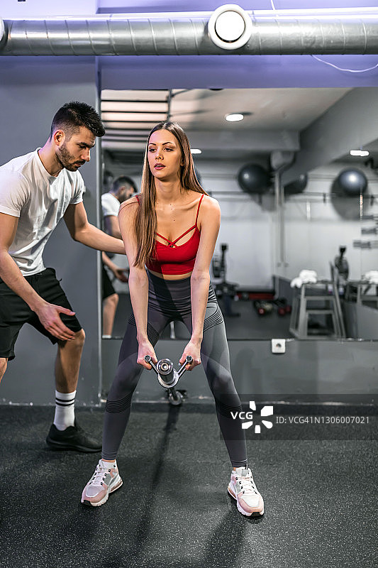 在健身房举重的健壮年轻健身女子图片素材