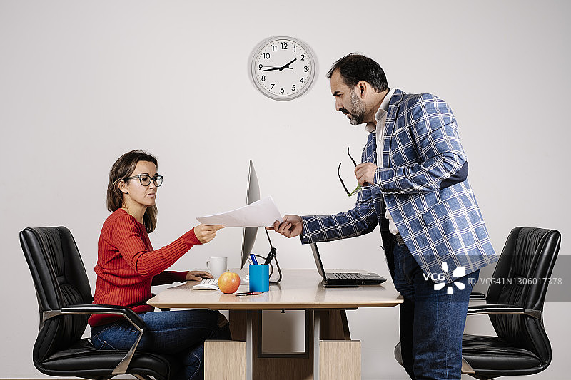 男人在办公室里把文件交给他的秘书图片素材