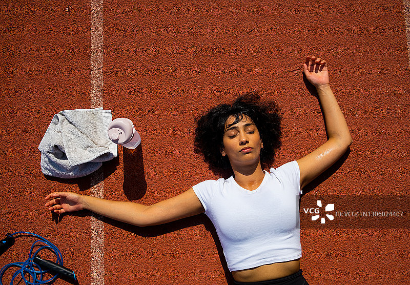 在体育场运动的女人用毛巾擦拭汗水图片素材