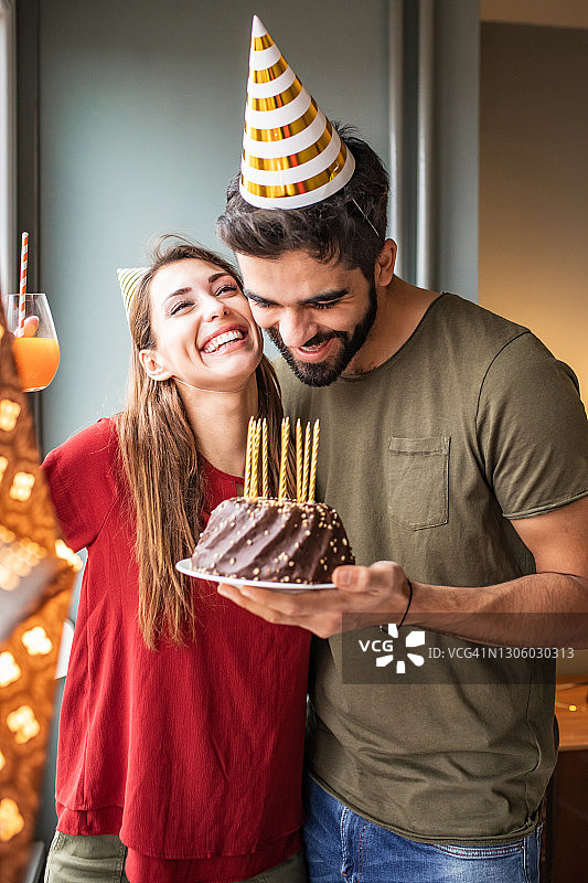 情侣在家中庆祝生日，享用生日蛋糕图片素材