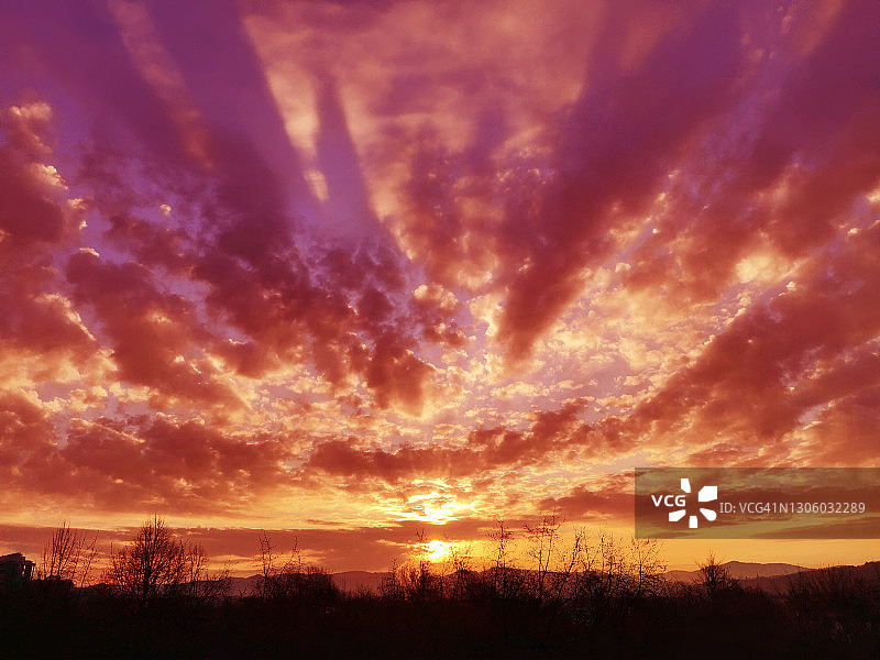 粉紫色橙黄色日出与零星的卷积云图片素材