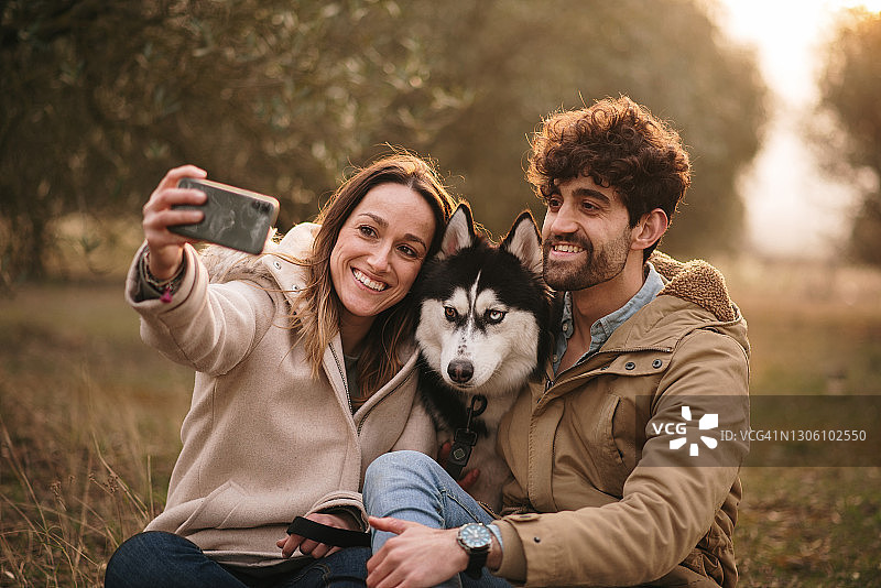 年轻夫妇和他们的哈士奇狗自拍图片素材