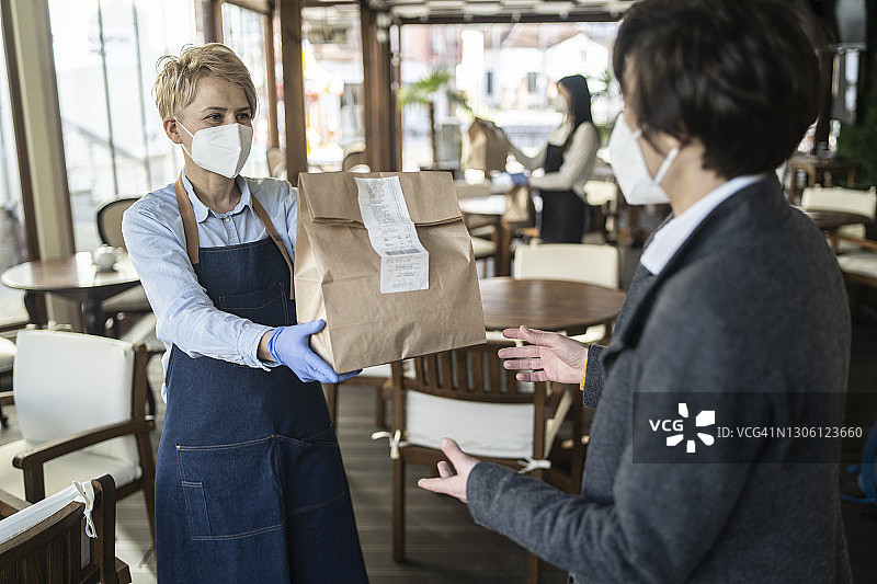 女服务员为顾客提供外卖餐点图片素材