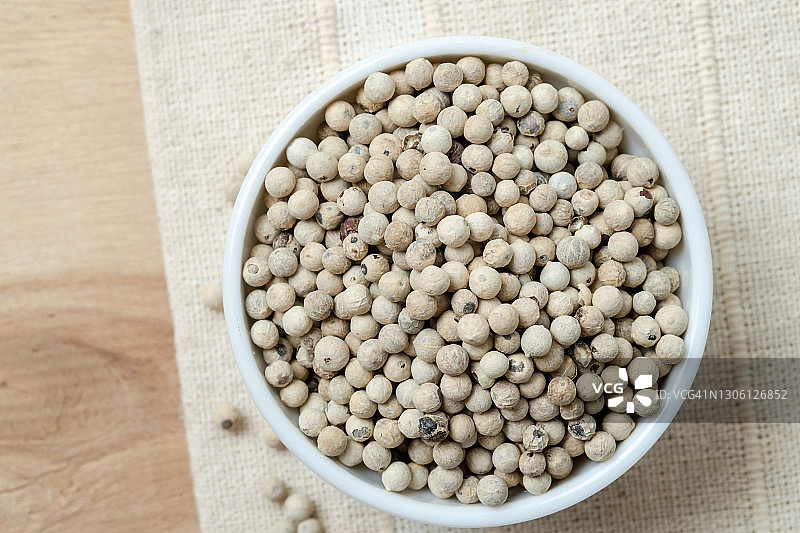 乡村木桌上的陶瓷碗装有机白胡椒图片素材
