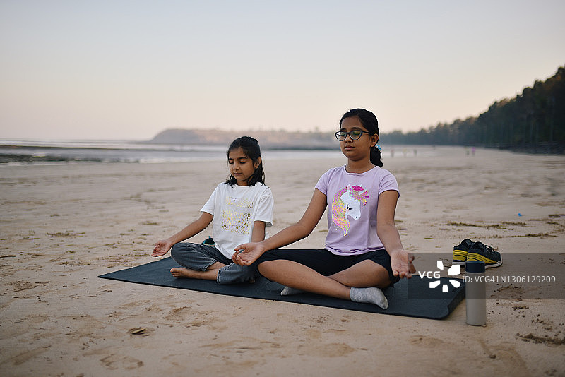 两个女孩在海滩上冥想图片素材