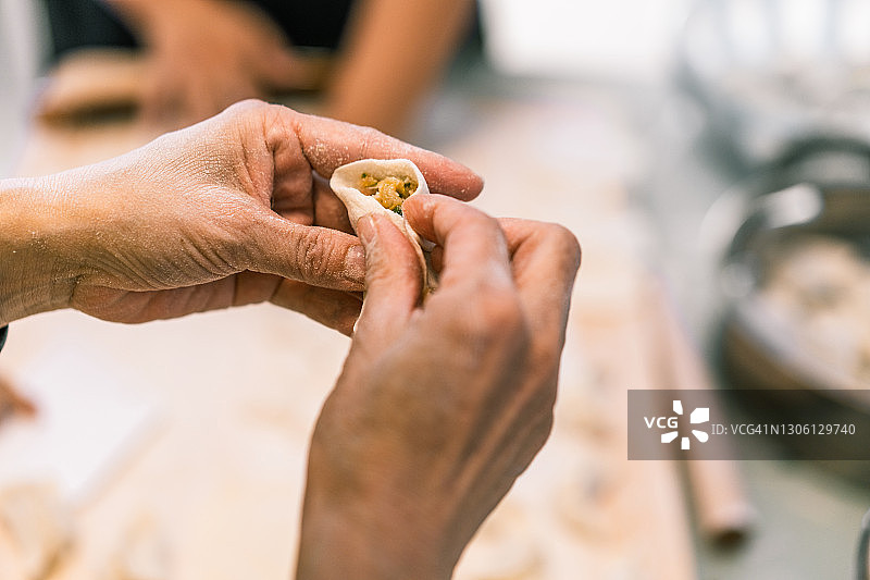 妇女在包饺子，只用手图片素材