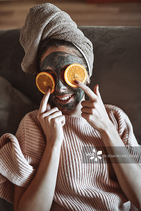 女子敷面膜放松时在眼睛上放橘子图片素材