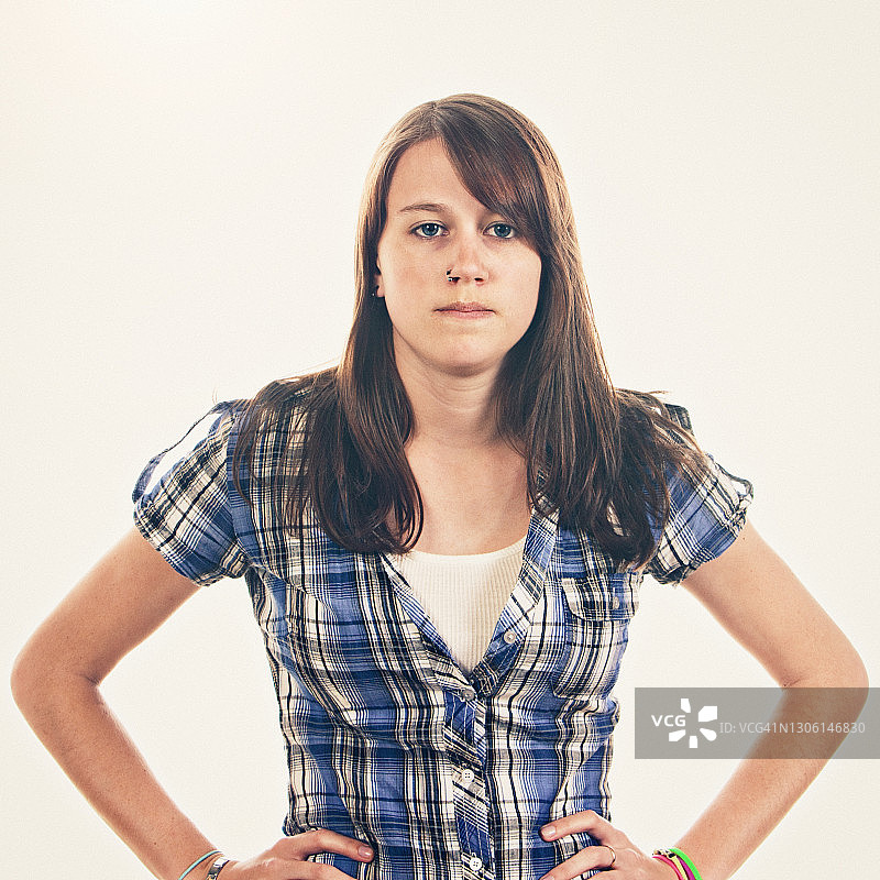 双手叉腰，看起来恼怒和生气的年轻女人图片素材